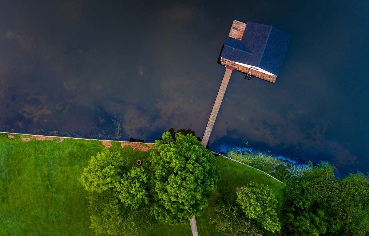 guntersville lake blue wooden house on body of water near green trees trees